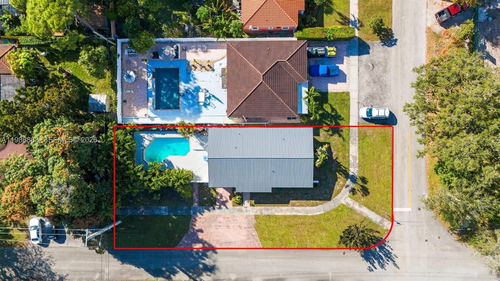 A swimming pool with a concrete deck is surrounded by lush tropical trees and shrubs — 8850 NE 4th Ave, El Portal FL 33138, EL PORTAL, FL