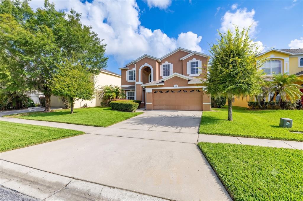 A two-story suburban house with a tan stucco exterior and a two-car garage — 9931 HERON POINTE DRIVE, ORLANDO, FL