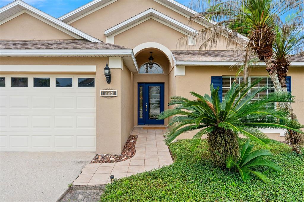The exterior of a tan house features a blue front door and a garage — 114 STONE GABLE CIRCLE, WINTER SPRINGS, FL