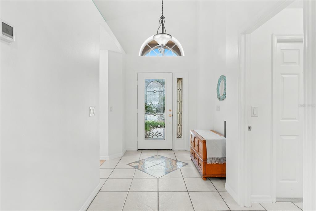 A bright entryway features white walls, tiled flooring with a decorative inlay, and a glass-paneled door — 114 STONE GABLE CIRCLE, WINTER SPRINGS, FL