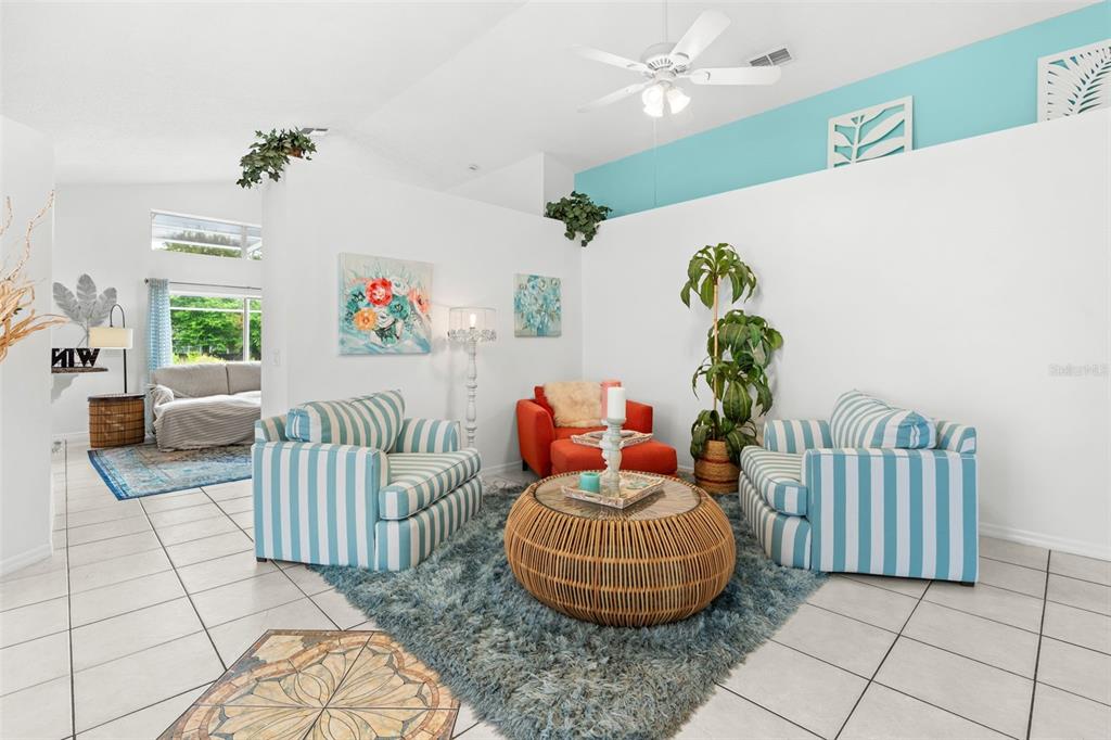 A living room features two striped armchairs, an orange chair, and a round wicker coffee table — 114 STONE GABLE CIRCLE, WINTER SPRINGS, FL
