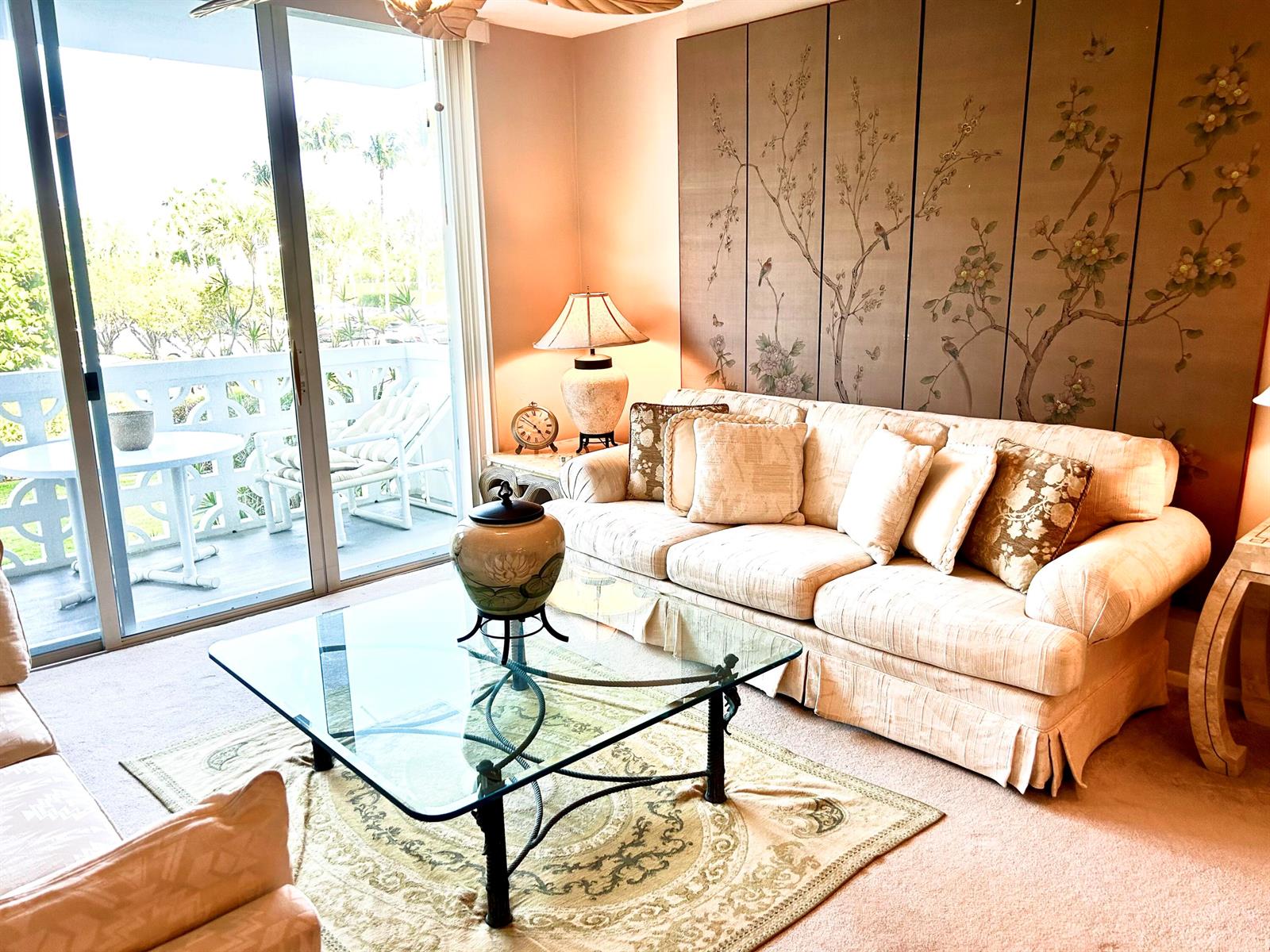 A living room features a beige sofa, glass coffee table, and a large floral wall mural — 2840 S Ocean Boulevard # 2210, Palm Beach FL 33480, PALM BEACH, FL