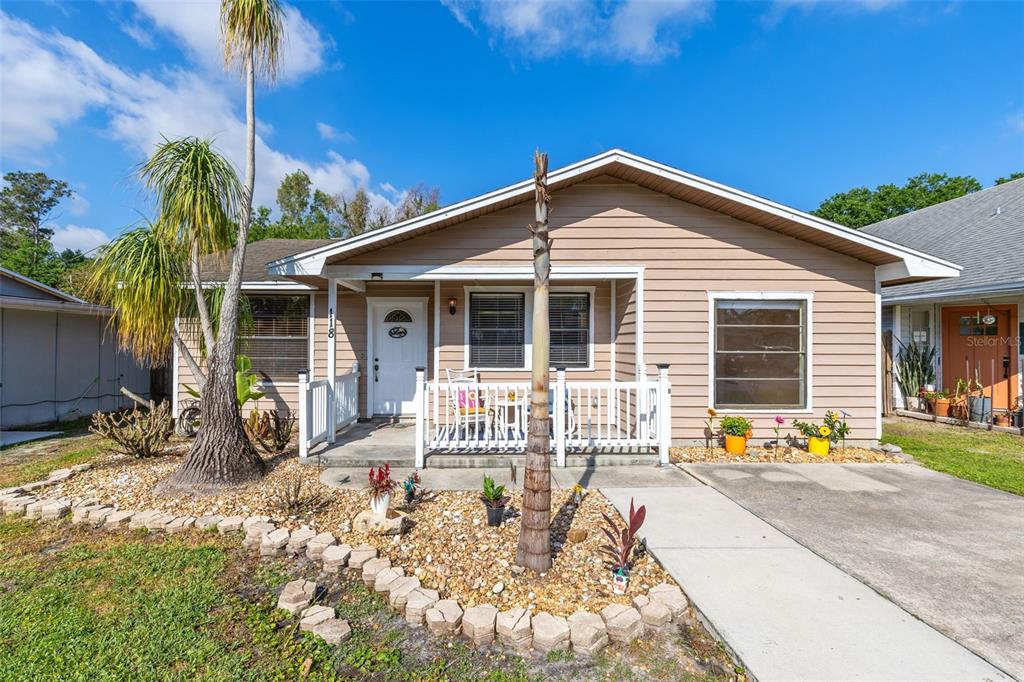A single-story house with tan horizontal siding, a front porch, and a gravel yard — 118 GEORGIA AVENUE, ST CLOUD, FL