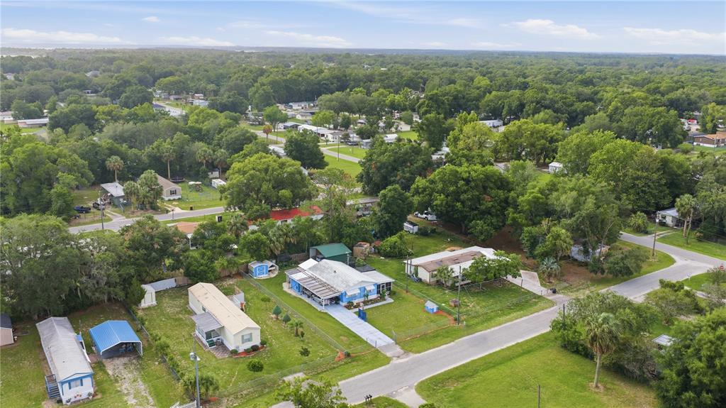 An aerial view of a residential neighborhood featuring several mobile homes and lush green trees — 14121 SE 91ST COURT, SUMMERFIELD, FL