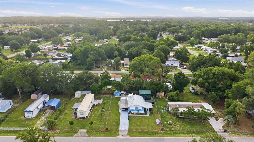 An aerial view shows several single-story homes with driveways and yards in a wooded neighborhood — 14121 SE 91ST COURT, SUMMERFIELD, FL