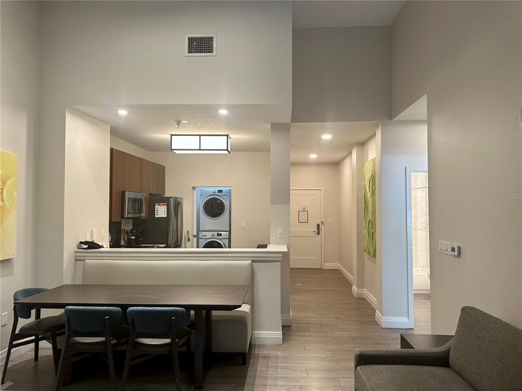 A dining area with a built-in bench and table opens to a kitchen and hallway — 14501 GROVE RESORT AVENUE UNIT 2101, WINTER GARDEN, FL