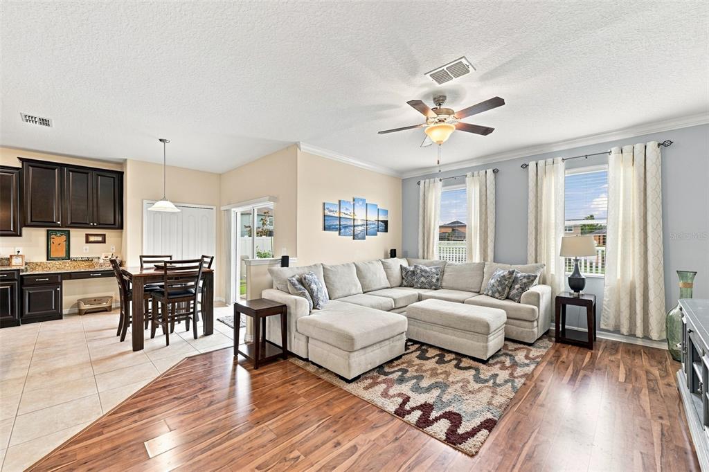 A living room with a sectional sofa, area rug, and an adjacent dining area — 12335 BALLENTRAE FOREST DRIVE, RIVERVIEW, FL
