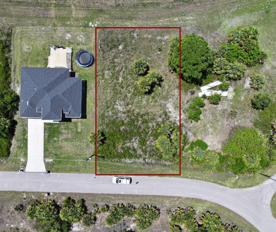 An aerial view shows a vacant rectangular lot outlined in red next to a house — Lot 22 EASTMAN CIRCLE, NORTH PORT, FL