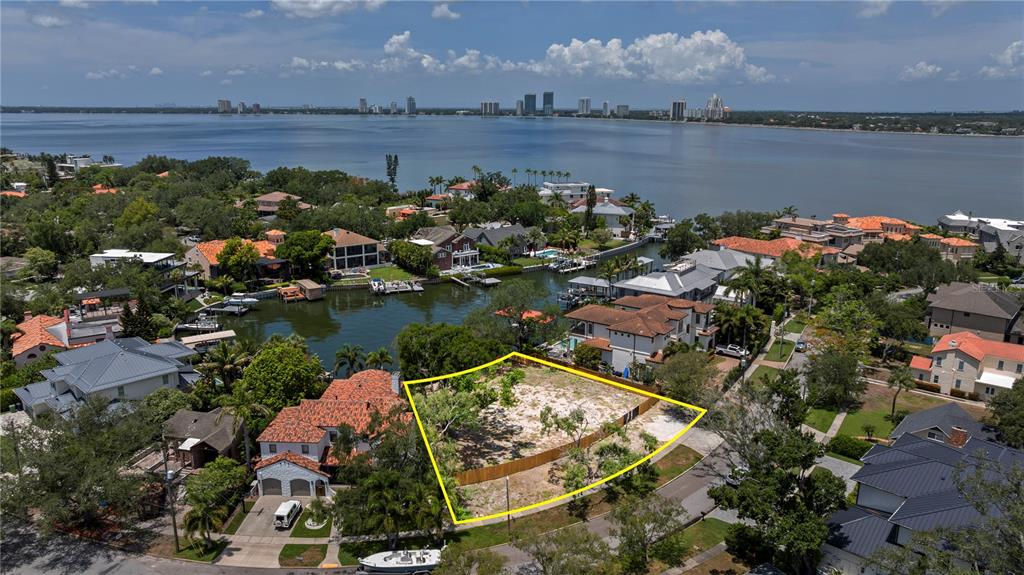 An aerial view shows a vacant lot surrounded by waterfront homes and a large bay — 86 BAHAMA CIRCLE, TAMPA, FL