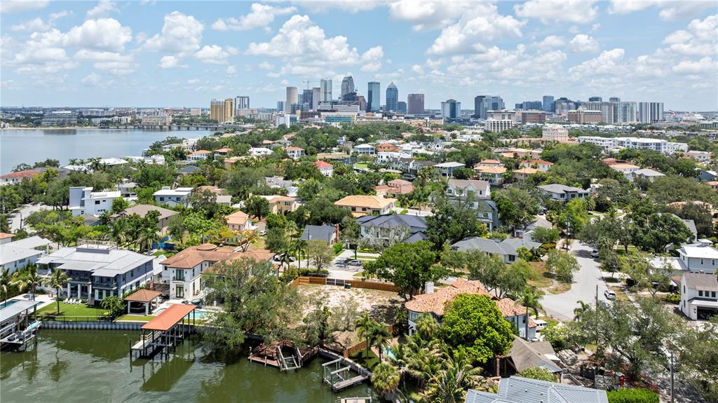 An aerial view shows a vacant waterfront lot enclosed by a wooden fence — 86 BAHAMA CIRCLE, TAMPA, FL