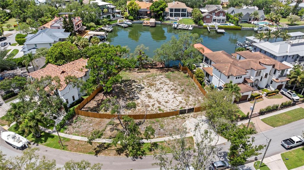 An aerial view shows a vacant waterfront lot situated between two existing residential properties — 86 BAHAMA CIRCLE, TAMPA, FL