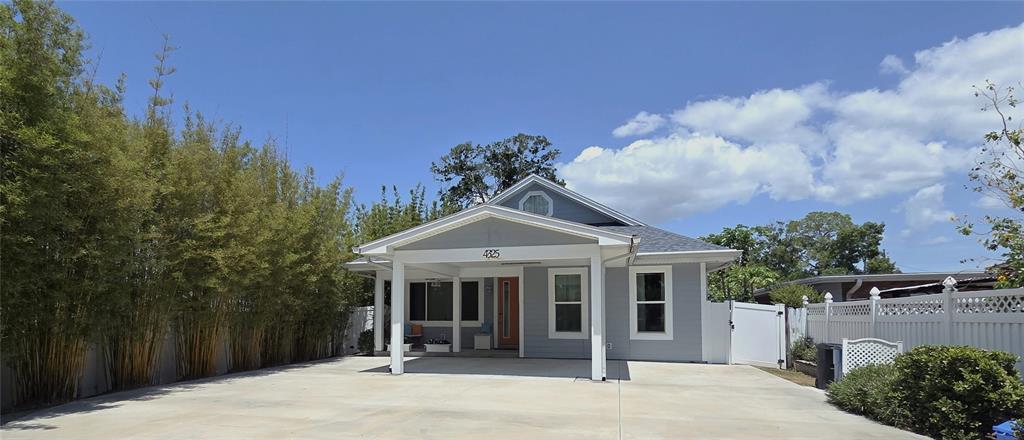 A light blue single-story house features a covered front porch and a large concrete driveway — 4325 78TH AVENUE N, PINELLAS PARK, FL