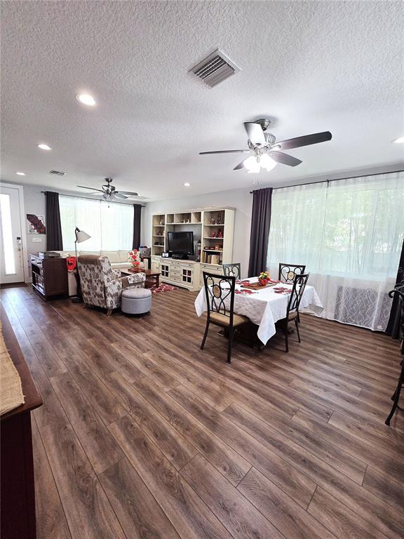 An open-concept living and dining area features wood-look flooring, recessed lighting, and ceiling fans — 4325 78TH AVENUE N, PINELLAS PARK, FL