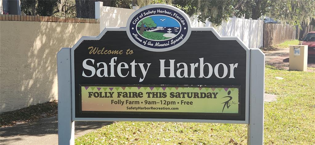 A sign welcomes visitors to Safety Harbor, Florida, and advertises a local event at Folly Farm — 304 LOS PRADOS UNIT 304, SAFETY HARBOR, FL