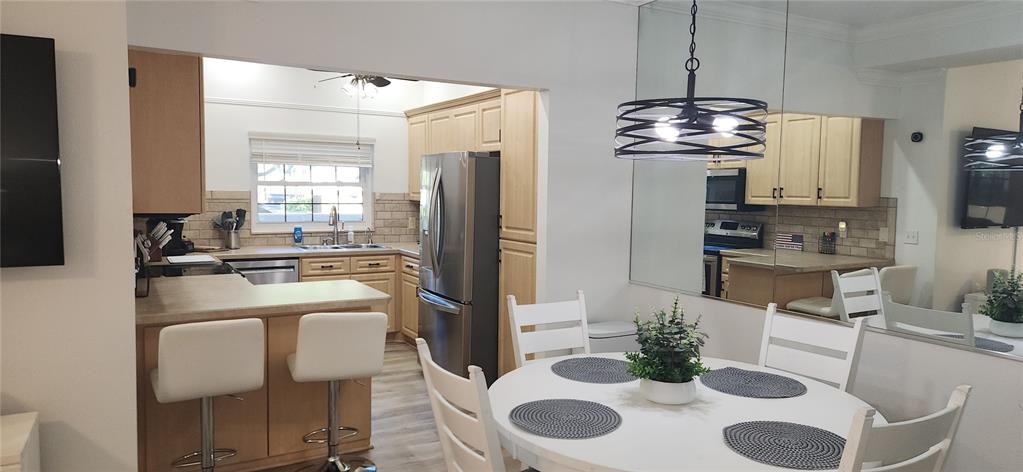 A kitchen with light wood cabinets and a dining area with a round white table — 304 LOS PRADOS UNIT 304, SAFETY HARBOR, FL