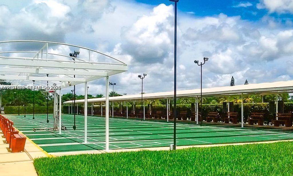 An outdoor shuffleboard court area features multiple lanes, covered seating, and overhead lighting — 111 Tilford F # 111, Deerfield Beach FL 33442, DEERFIELD BEACH, FL