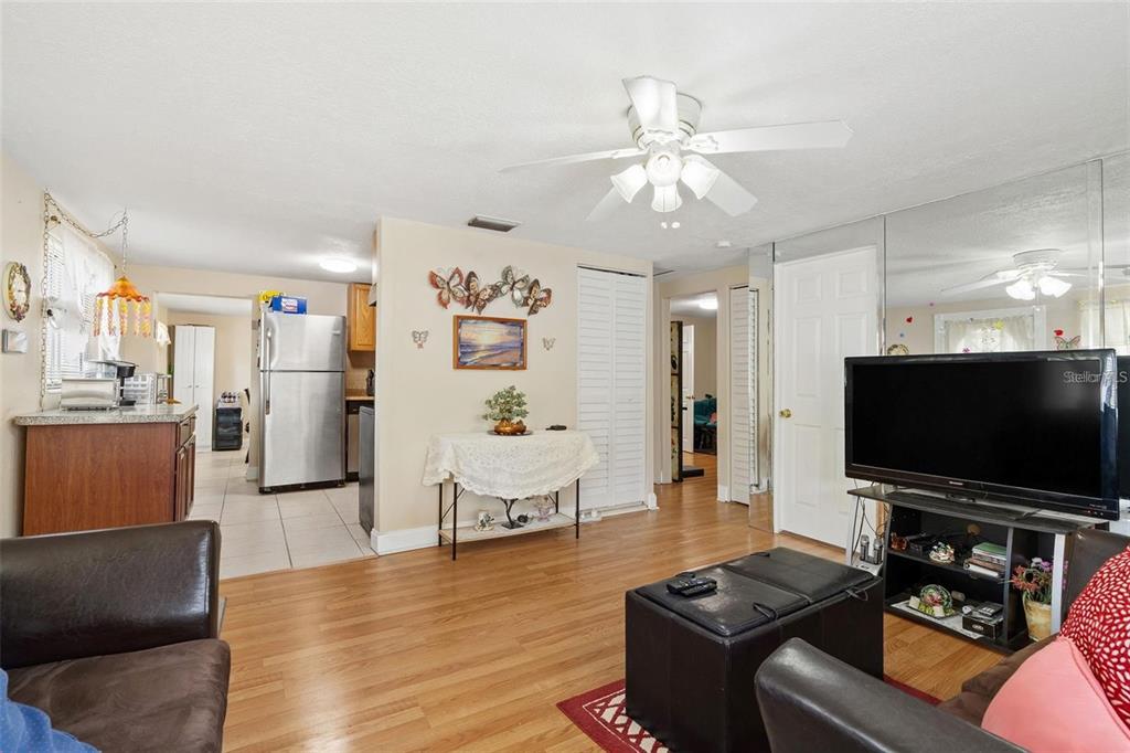 A living room with wood flooring, a ceiling fan, and an adjacent kitchen — 4530 72ND AVENUE N, PINELLAS PARK, FL