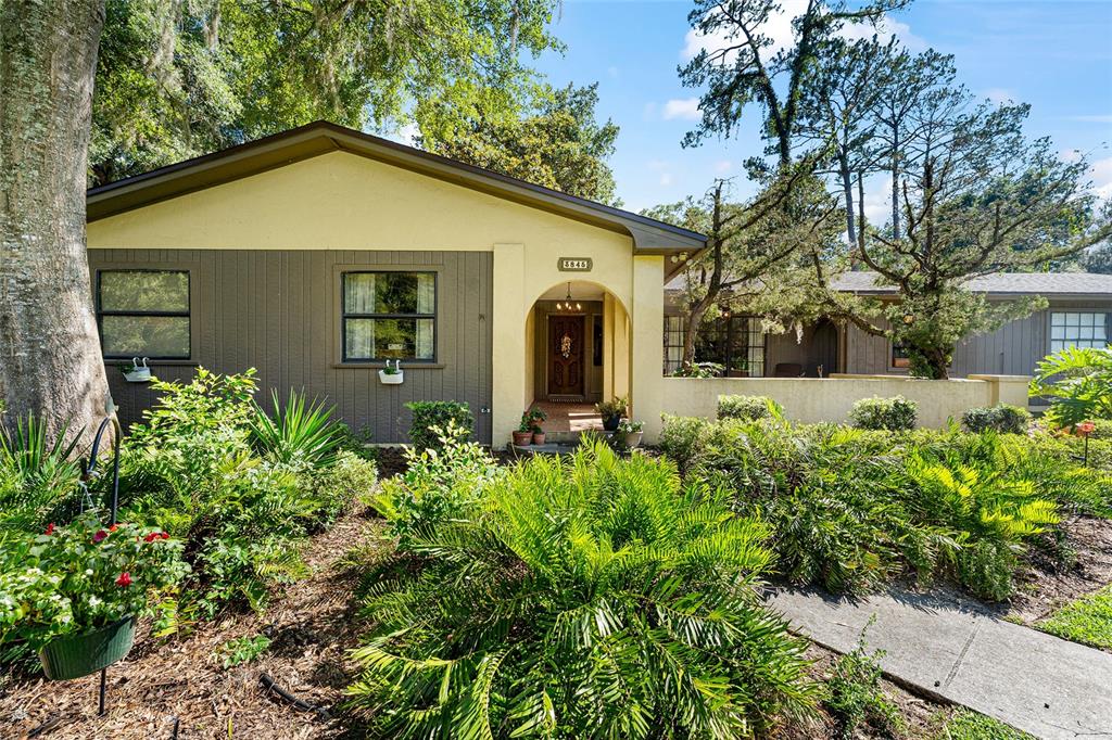 A single-story house with a yellow and brown exterior features a covered entryway and landscaping — 3845 NW 37TH PLACE, GAINESVILLE, FL