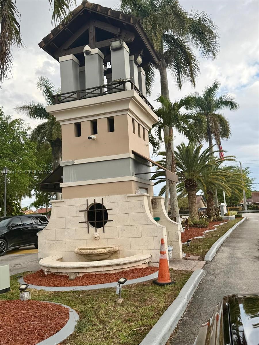 A tall, multi-tiered stucco tower structure features a circular window, fountain, and palm trees — 3858 SW 153rd Pl, Miami FL 33185, MIAMI, FL