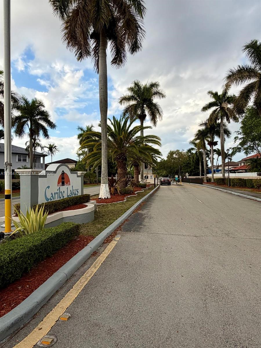 A street leads to the gated entrance of a residential community named Caribe Lakes — 3858 SW 153rd Pl, Miami FL 33185, MIAMI, FL