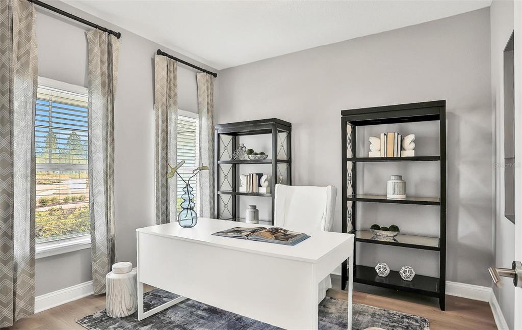 A home office features a white desk, two black bookshelves, and windows with patterned curtains — 765 PINTAIL TERRACE, ORANGE PARK, FL