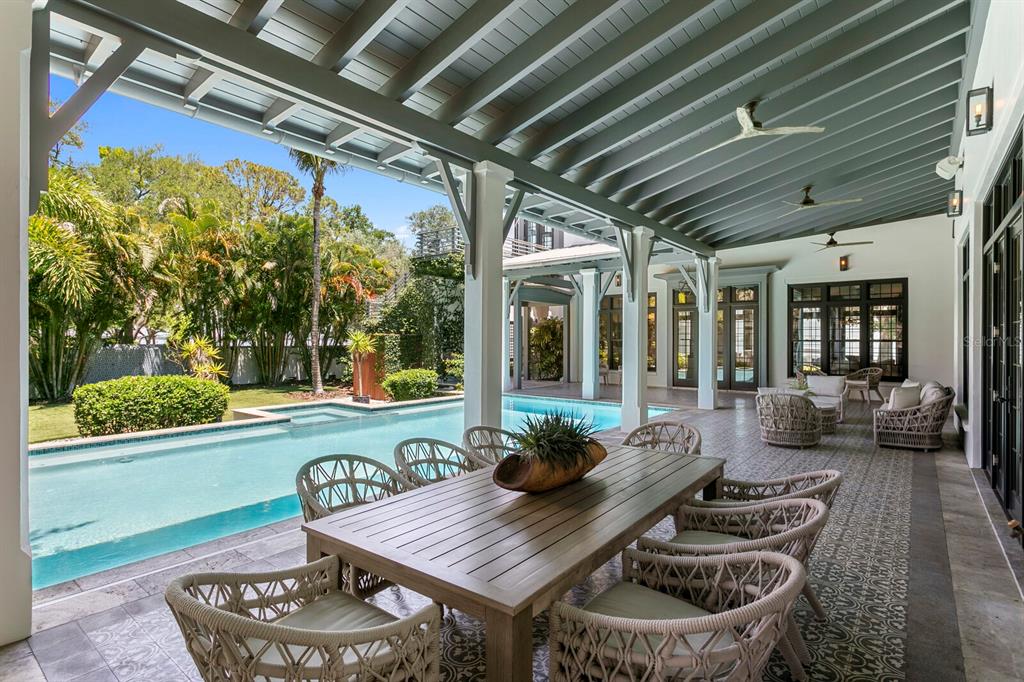 A covered outdoor patio features a dining table, lounge seating, and a swimming pool — 4613 BAYSHORE BOULEVARD, TAMPA, FL