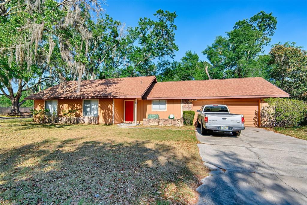 A single-story house with orange siding, a red front door, and a two-car garage — 4347 NW 43RD TERRACE, GAINESVILLE, FL