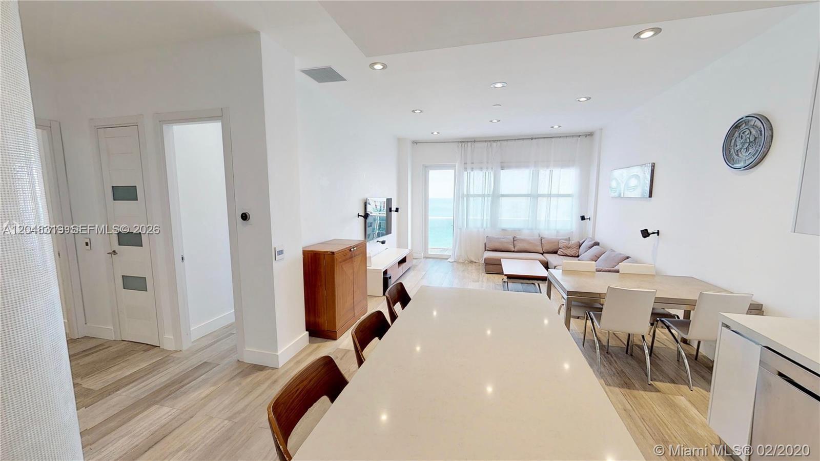 A modern, open-concept living and dining area features light wood flooring and white walls — 3725 S Ocean Dr, Hollywood FL 33019, HOLLYWOOD, FL