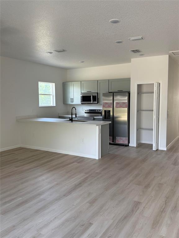 A kitchen with light gray cabinets, stainless steel appliances, and a breakfast bar island — 14685 SW 22 PLACE, OCALA, FL