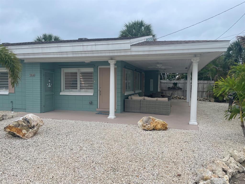 A teal-colored house with a covered patio, white columns, and a gravel front yard — 720 E GULF BOULEVARD UNIT B, INDIAN ROCKS BEACH, FL