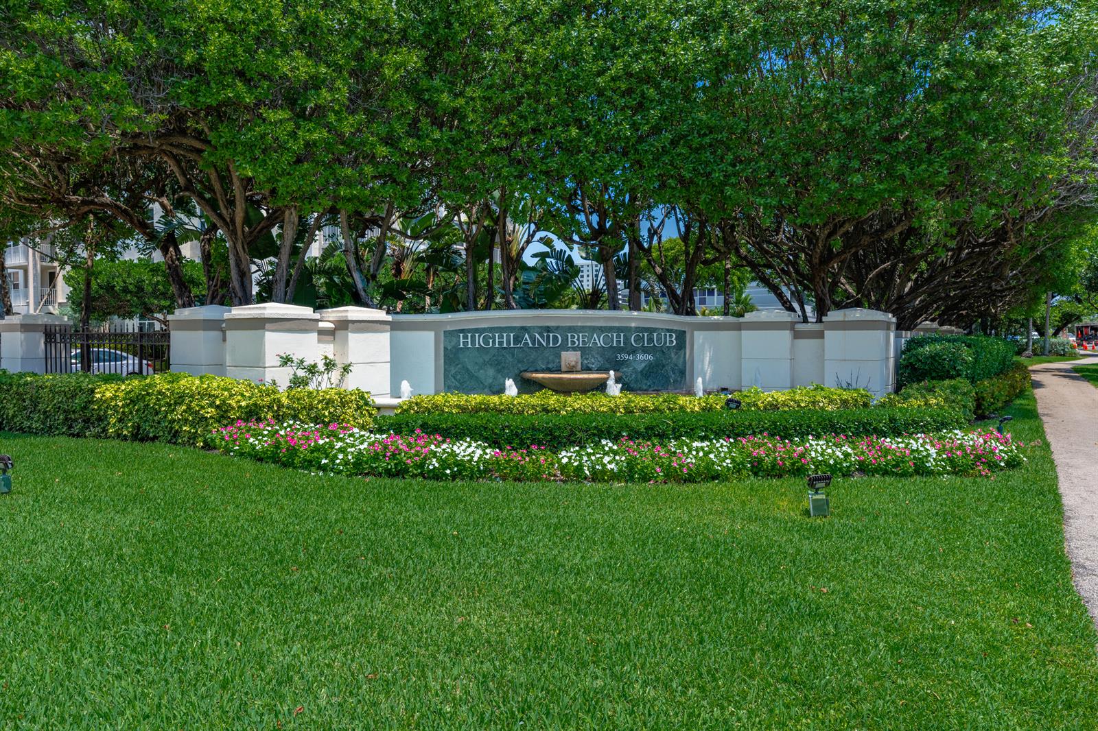 A stone monument sign for Highland Beach Club sits behind a manicured lawn and flowers — 3594 S Ocean Boulevard # 604, Highland Beach FL 33487, HIGHLAND BEACH, FL