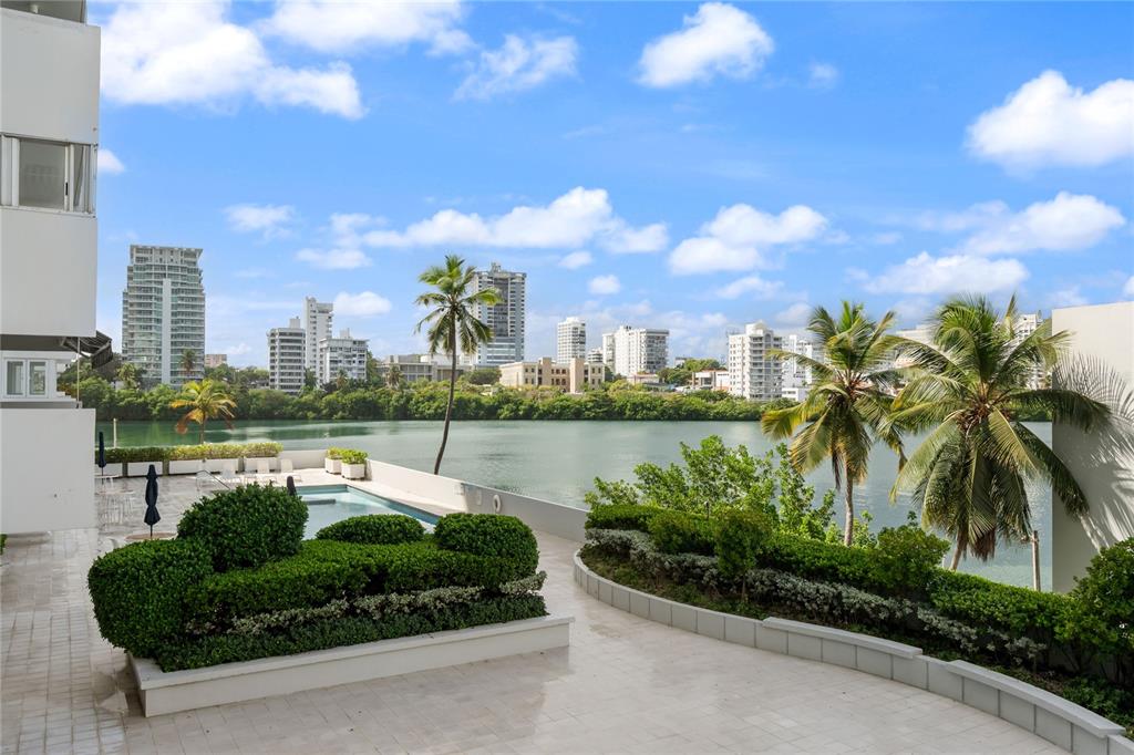 A terrace with a swimming pool overlooks a lagoon and a city skyline — #6 MARIANO RAMÍREZ BAGES UNIT 1, SAN JUAN, PR