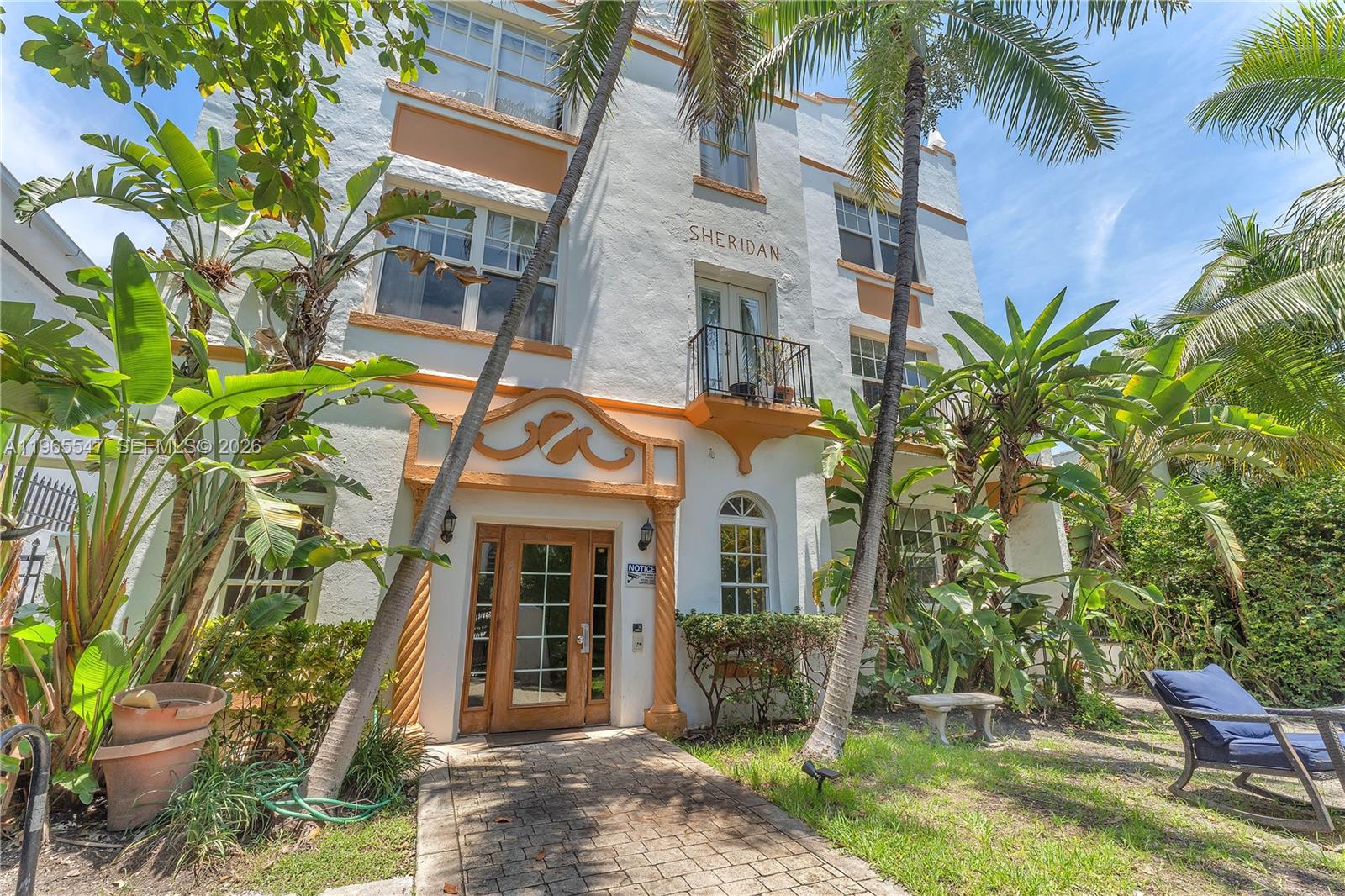 The exterior of a white multi-story building named Sheridan features a front entrance and landscaping — 737 Jefferson Ave # 305, Miami Beach FL 33139, MIAMI BEACH, FL