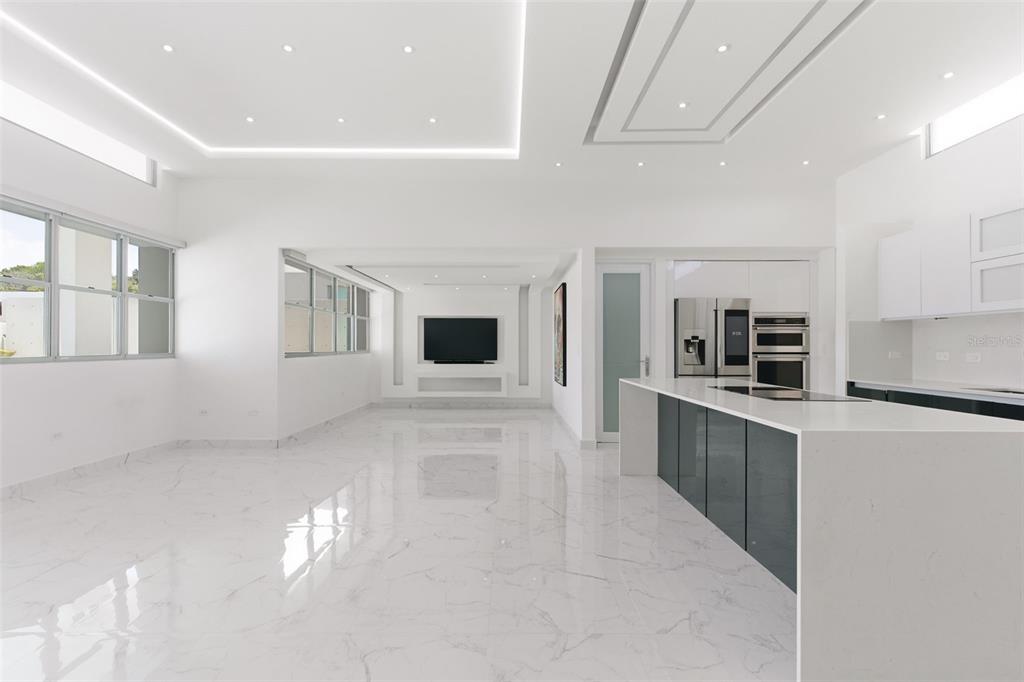 A modern, open-concept kitchen and living area with white marble floors and recessed lighting — MONTECIELO LYRA ST., GUAYNABO, PR