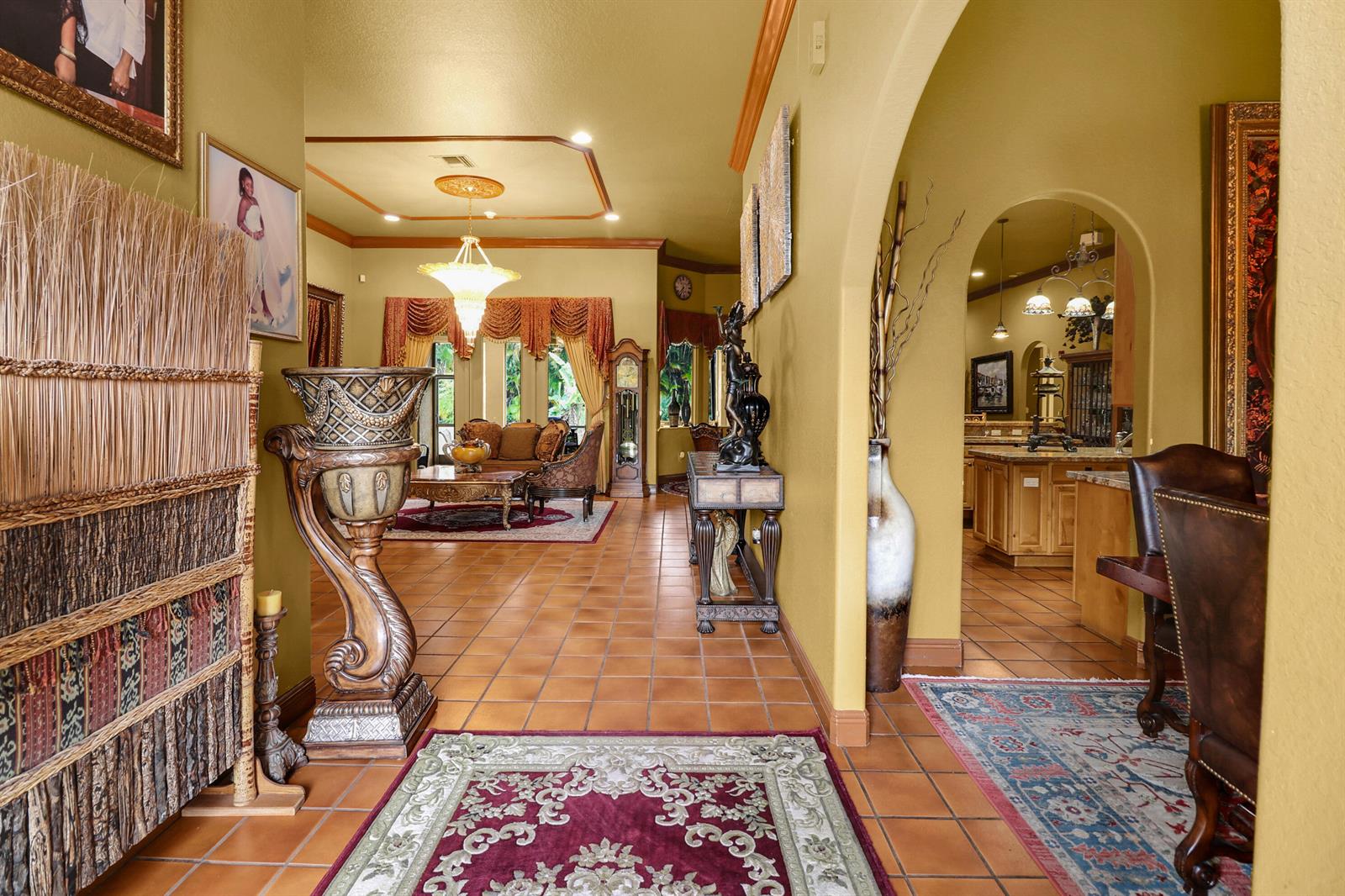 A tiled hallway leads to a living room and kitchen with arched doorways and warm-toned walls — 7086 Hall Boulevard, FL 33470, FL