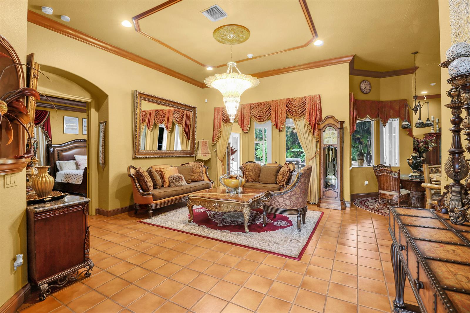 A formal living room features tile floors, a large chandelier, and ornate traditional furniture — 7086 Hall Boulevard, FL 33470, FL