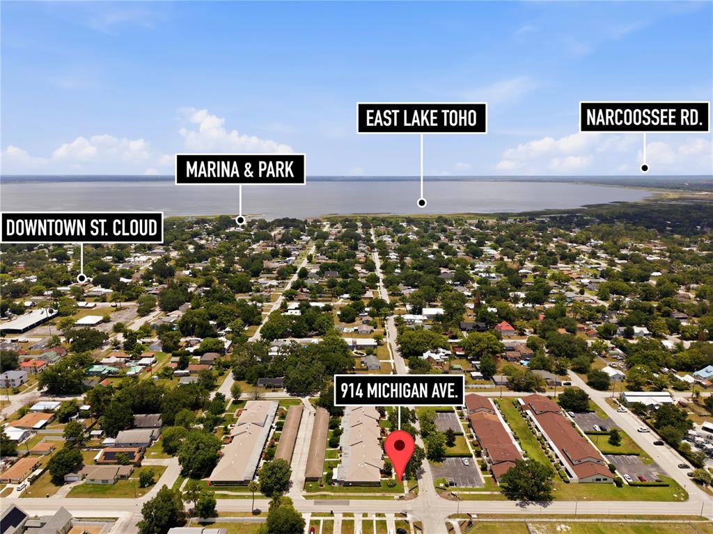 This aerial view shows a residential apartment complex near a large lake and park — 914 MICHIGAN AVENUE, ST CLOUD, FL