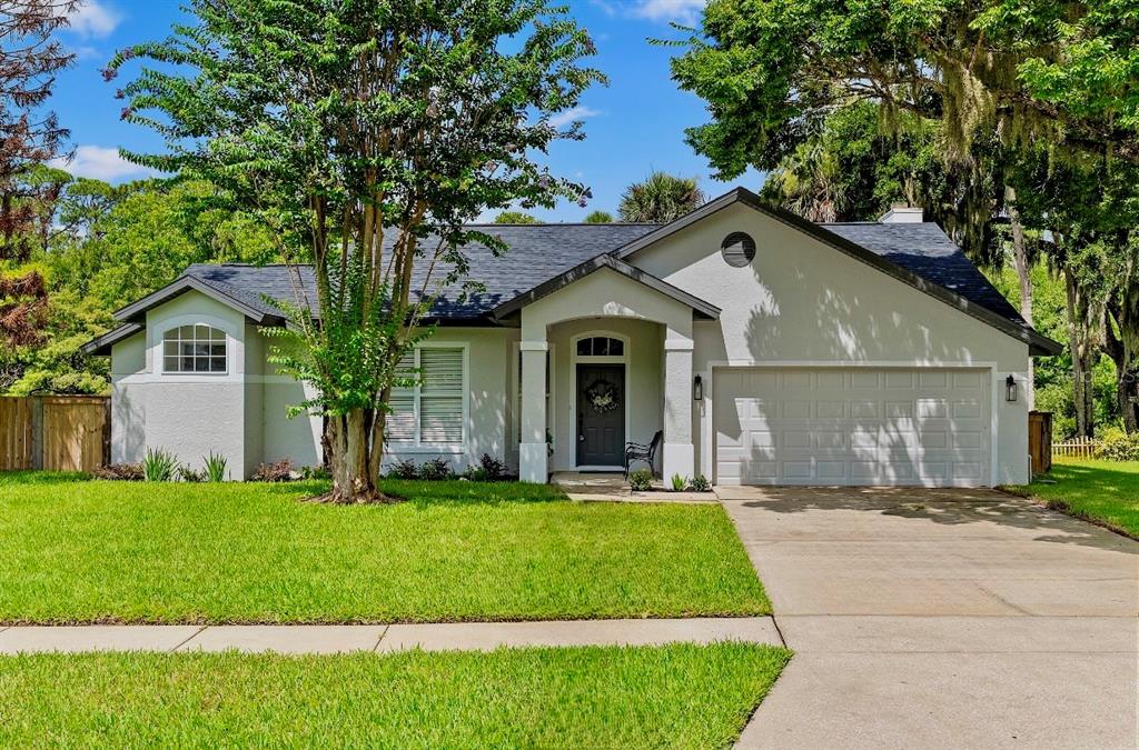 An aerial view shows a house with a dark roof situated beside a lake — 427 PENDREY DRIVE, PORT ORANGE, FL