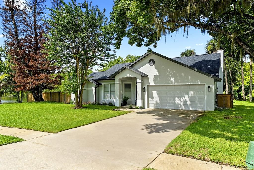 A single-story house with a gray roof, light-colored stucco exterior, and a two-car garage — 427 PENDREY DRIVE, PORT ORANGE, FL