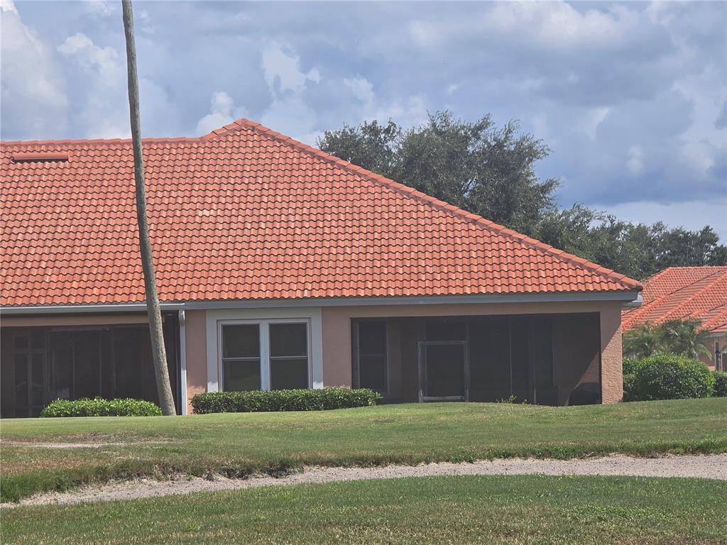 A single-story house with a terracotta tile roof and a screened-in back porch — 9007 VISTA VERDE DRIVE, PALMETTO, FL