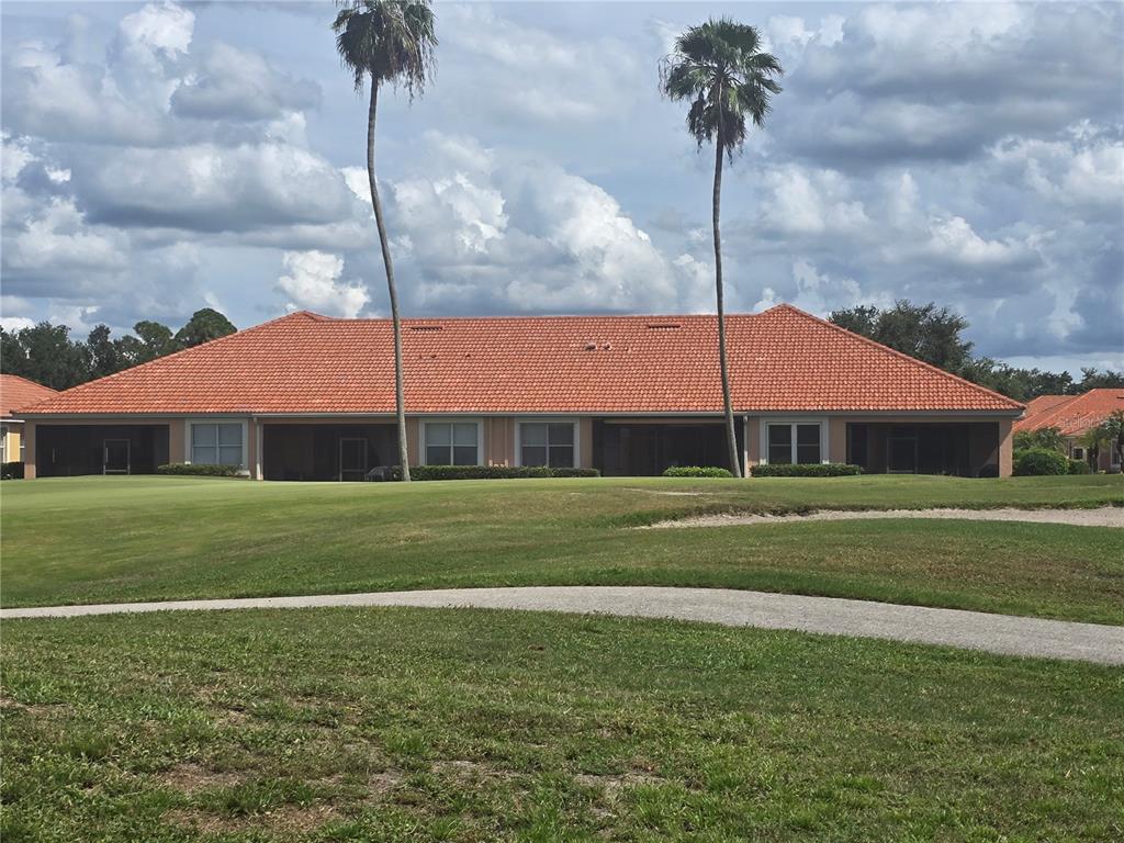 A single-story building with a red tile roof overlooks a golf course fairway — 9007 VISTA VERDE DRIVE, PALMETTO, FL