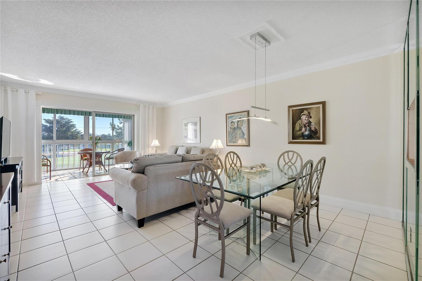 A living and dining area with tile floors, a glass table, and a balcony view — 7787 Golf Circle Drive # 312, Margate FL 33063, MARGATE, FL