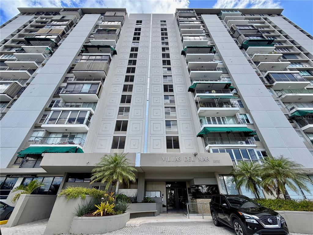 An empty room with marble floors, a modern chandelier, and floor-to-ceiling windows overlooking the ocean — Villas del Mar Este PH AV. ISLA VERDE UNIT H, CAROLINA, PR