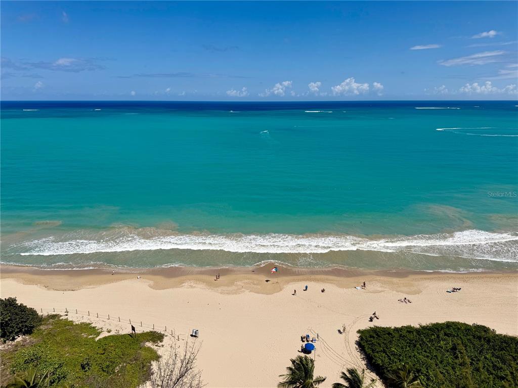 An empty room with light-colored tile floors and a wall of windows overlooking the ocean — Villas del Mar Este PH AV. ISLA VERDE UNIT H, CAROLINA, PR