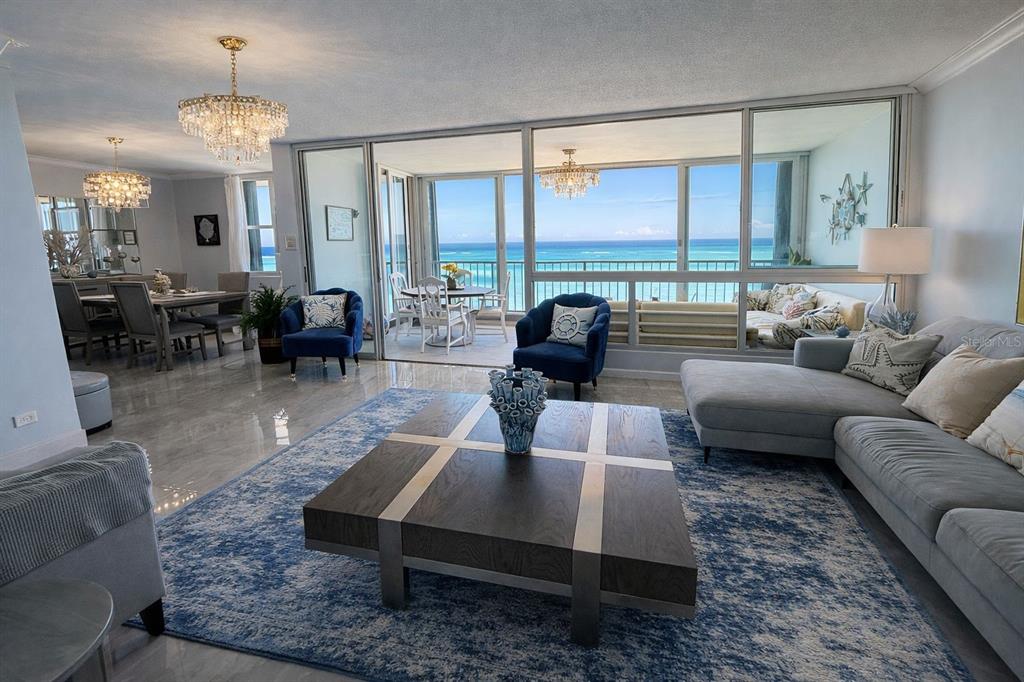 A balcony with a metal railing overlooks the ocean through a large sliding glass door — Villas del Mar Este PH AV. ISLA VERDE UNIT H, CAROLINA, PR
