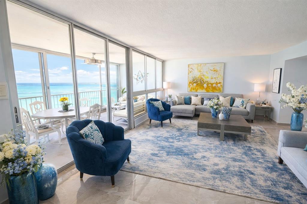 A modern kitchen features two-tone cabinets, stainless steel appliances, and a view of the ocean — Villas del Mar Este PH AV. ISLA VERDE UNIT H, CAROLINA, PR