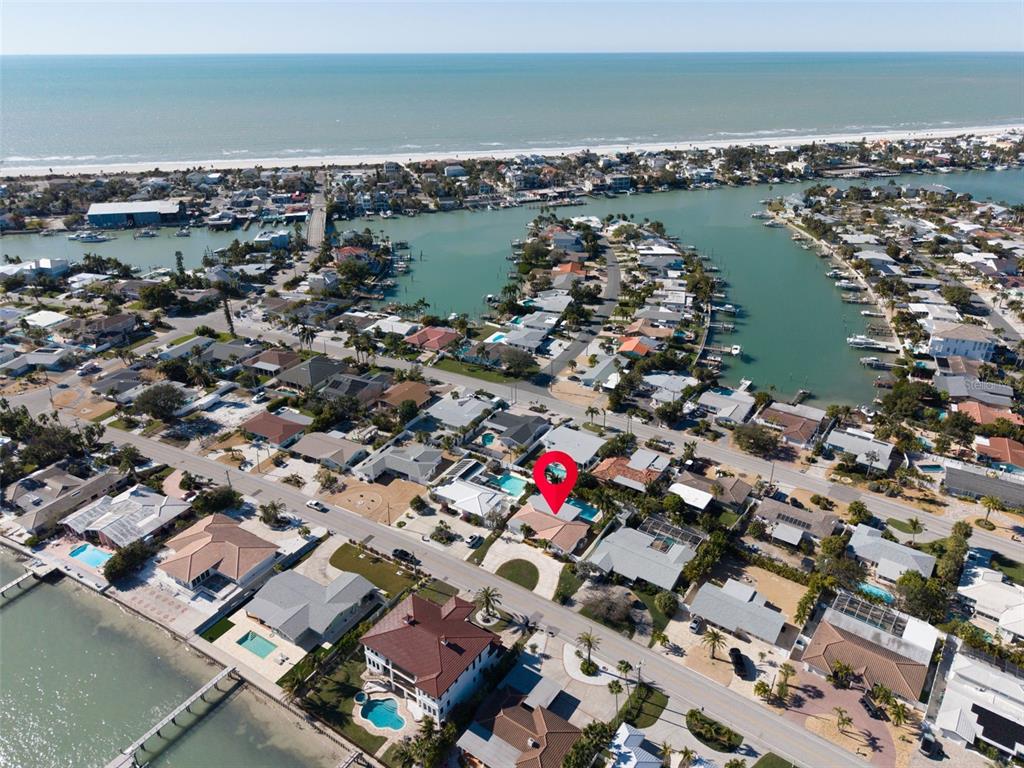 An aerial view shows a coastal residential neighborhood with a red pin marking a house — 2220 E VINA DEL MAR BOULEVARD, ST PETE BEACH, FL