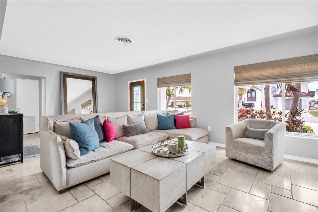 A living room features a large sectional sofa, a coffee table, and tile flooring — 2220 E VINA DEL MAR BOULEVARD, ST PETE BEACH, FL
