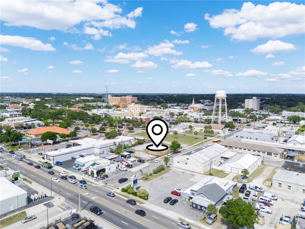 This is an aerial view of a commercial area with a map pin marker — 165 5TH STREET SW, WINTER HAVEN, FL