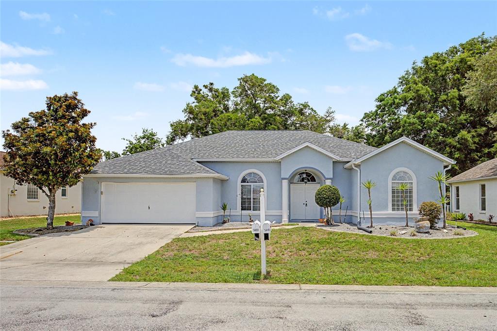 A light blue single-story house with a two-car garage and an arched entryway — 5455 NW 26TH LANE, OCALA, FL